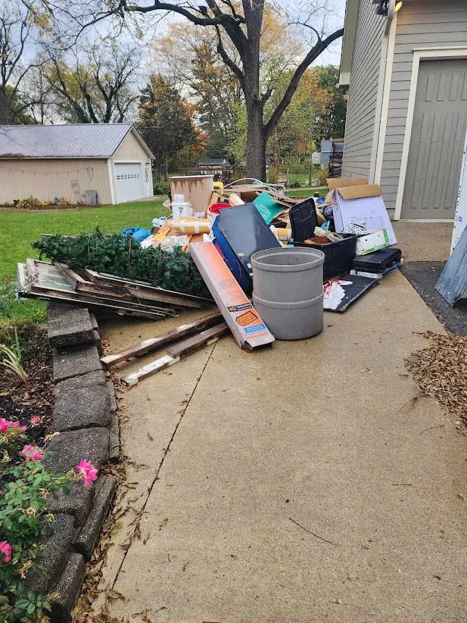Dumpster being loaded with debris for 12 Yard Dumpster Rental in Sudley